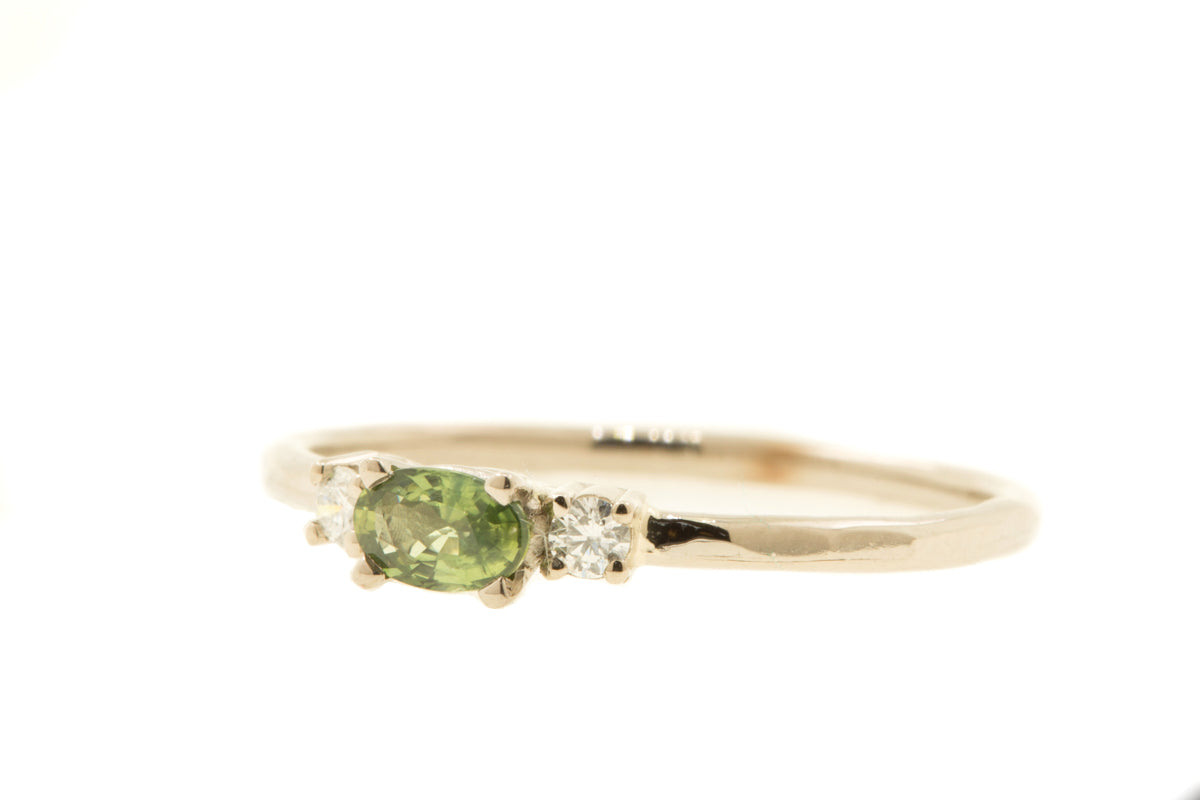 Handgemaakte en fairtrade fijne organische gouden ring met een groene ovale saffier en twee diamantjes