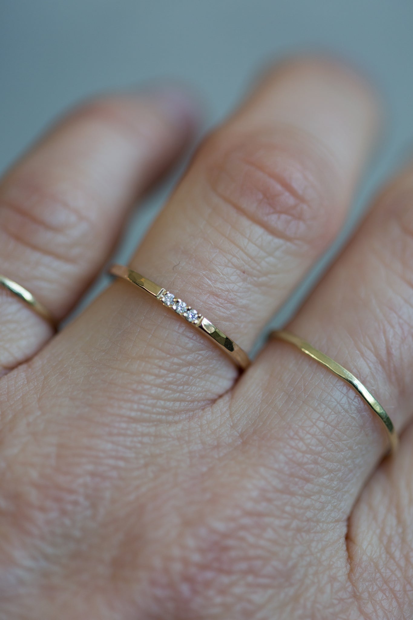 Handgemaakte en fairtrade fijne gehamerde gouden ring met drie kleine fairtrade diamantjes in een fishtail zetting