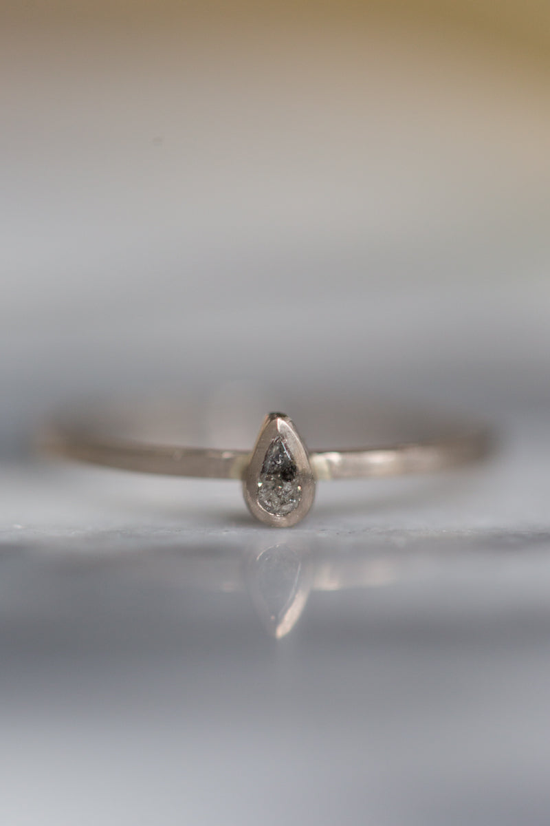 Handgemaakte en fairtrade fijne gehamerde witgouden ring met peervormige zout en peper diamant