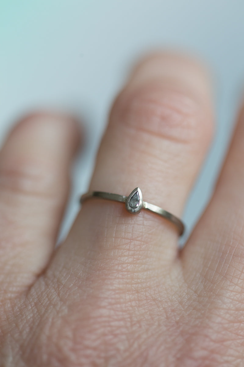 Handgemaakte en fairtrade fijne gehamerde witgouden ring met peervormige zout en peper diamant