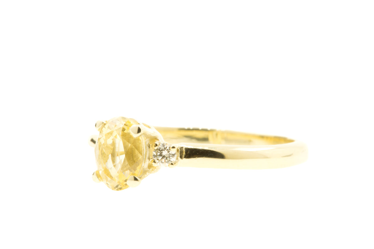 Handgemaakte en fairtrade geelgouden verlovingsring met ovale gele saffier en twee diamanten