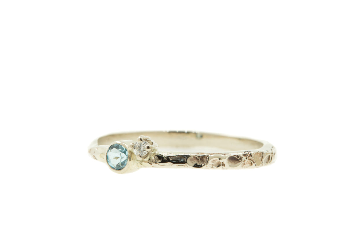 Handgemaakte en fairtrade witgouden ring met structuur en topaas en diamantje