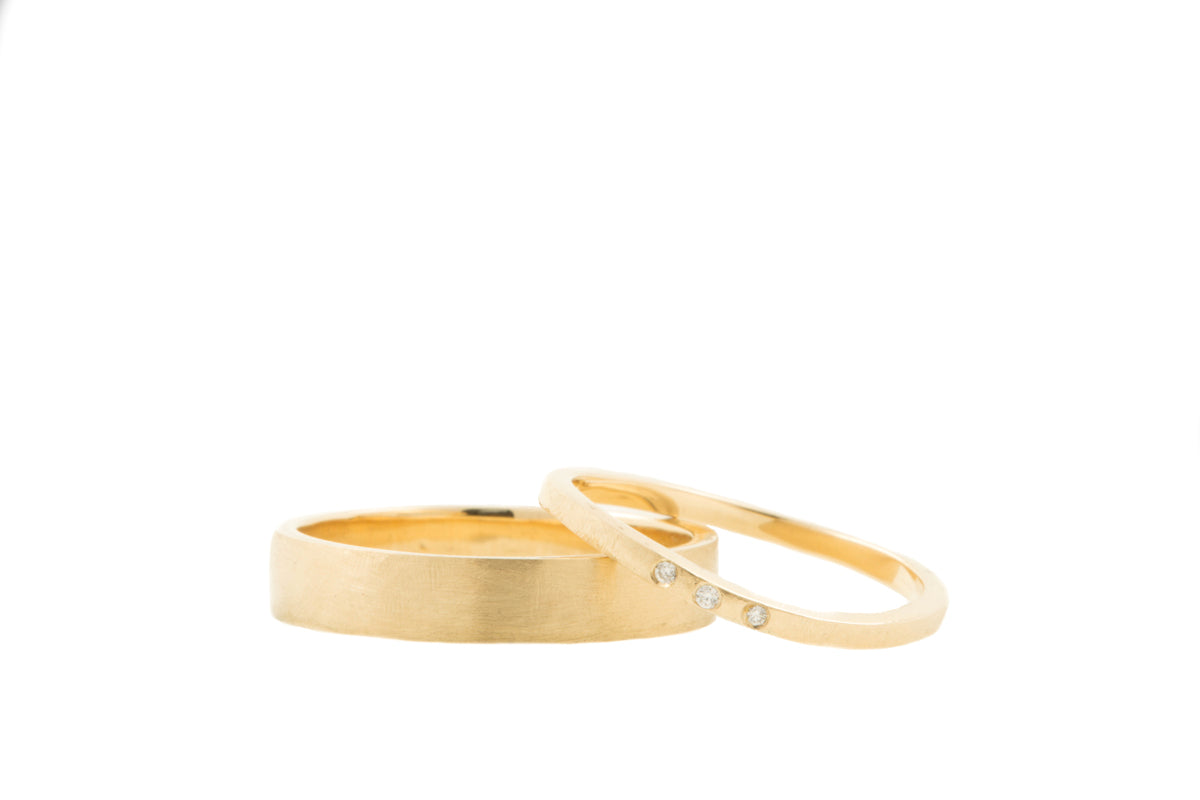 Handgemaakt en fairtrade. Set geelgouden trouwringen met drie diamantjes in de damesring.