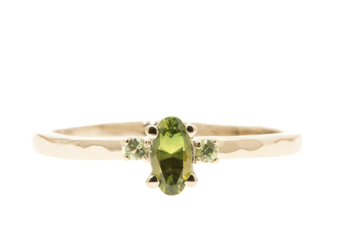 Handgemaakte en fairtrade witgouden verlovingsring met ovale bi-color saffier en twee groene saffiertjes