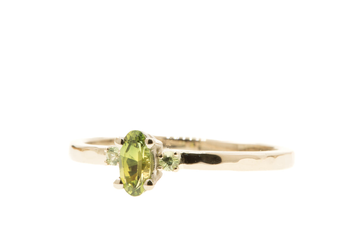 Handgemaakte en fairtrade witgouden verlovingsring met ovale bi-color saffier en twee groene saffiertjes