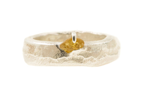 Handgemaakte en fairtrade zilveren sand cast ring met cast in place ruwe saffier