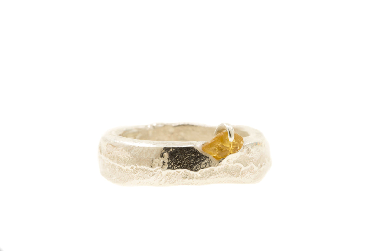 Handgemaakte en fairtrade zilveren sand cast ring met cast in place ruwe saffier