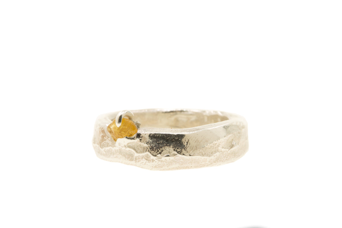 Handgemaakte en fairtrade zilveren sand cast ring met cast in place ruwe saffier