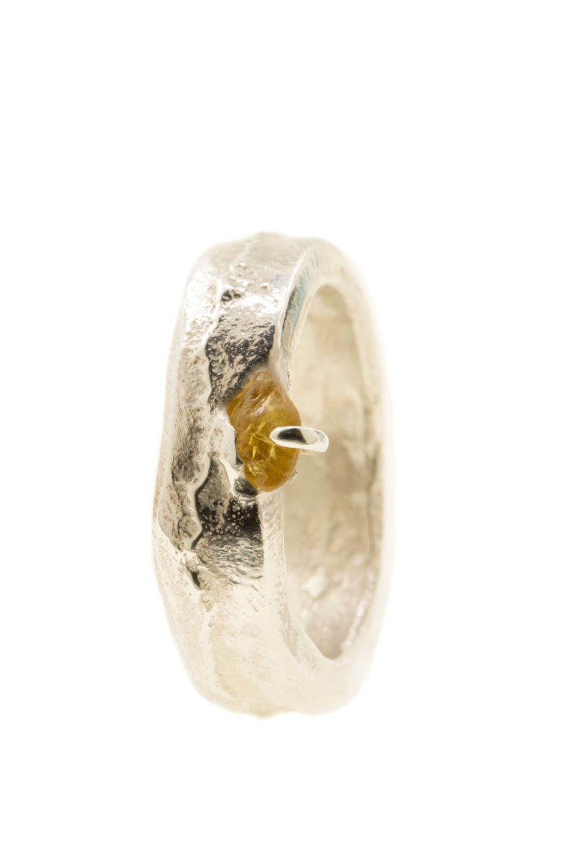 Handgemaakte en fairtrade zilveren sand cast ring met cast in place ruwe saffier