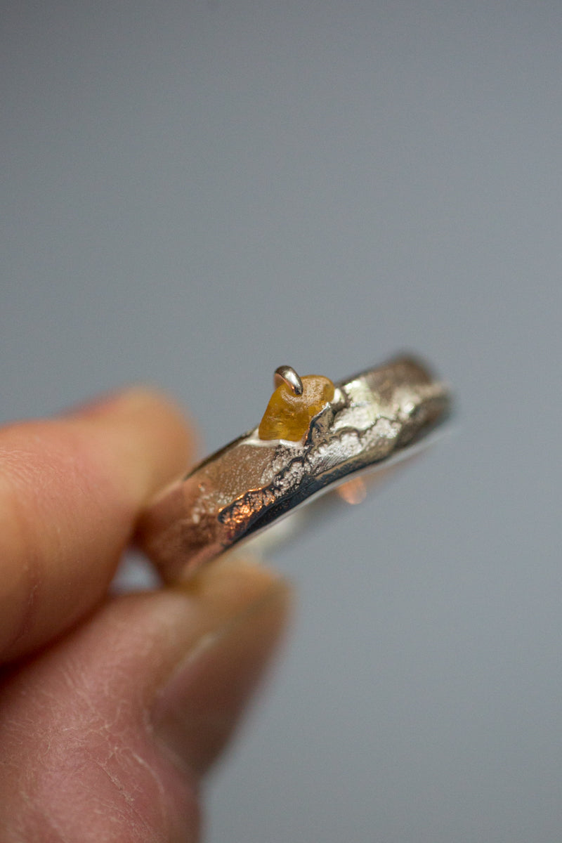 Handgemaakte en fairtrade zilveren sand cast ring met cast in place ruwe saffier