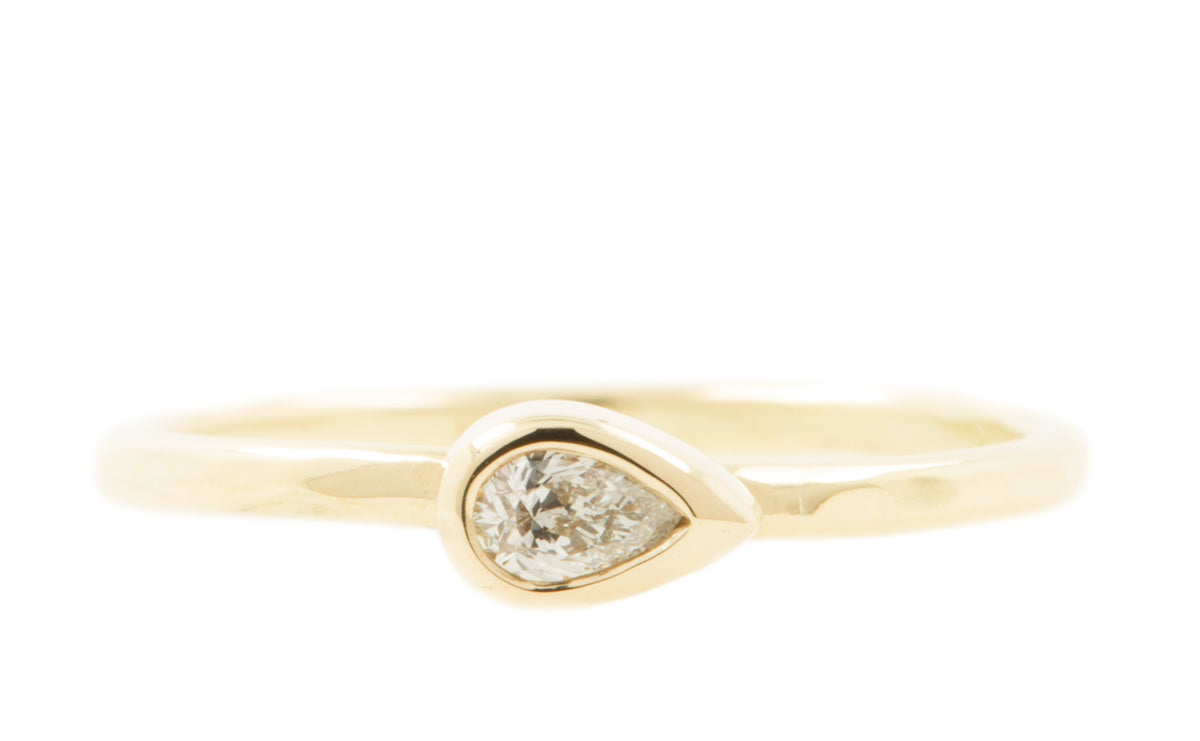 Handgemaakte en fairtrade fijne gehamerde geelgouden ring met peervormige diamant