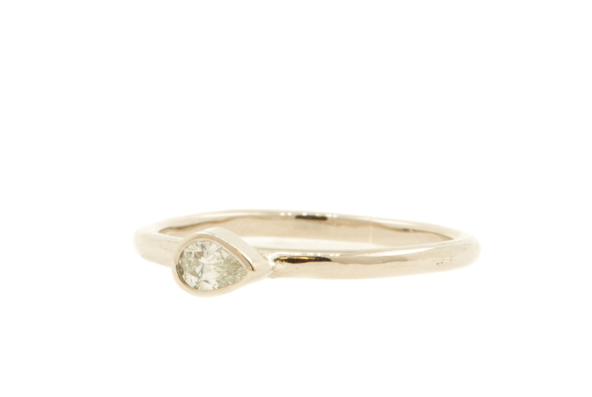 Handgemaakte en fairtrade fijne gehamerde witgouden ring met peervormige diamant