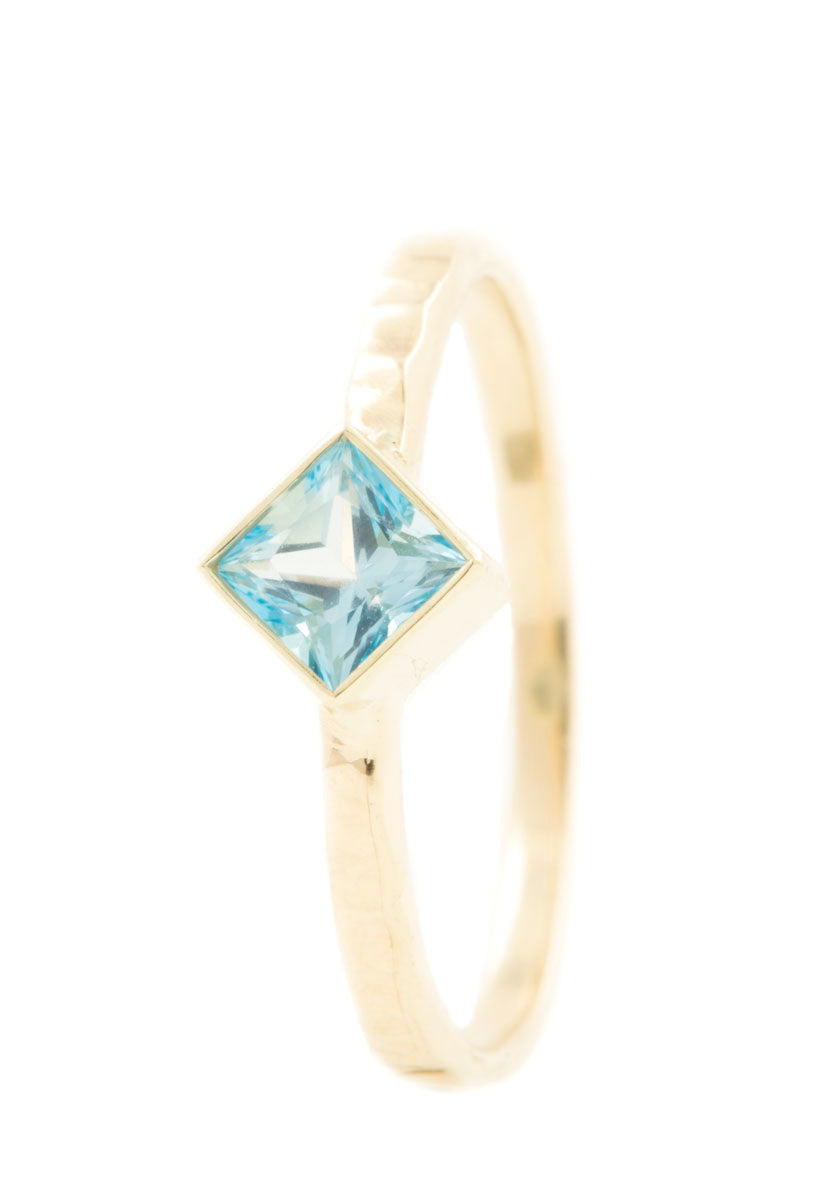 Handgemaakte en fairtrade geelgouden gehamerde ring met vierkante blauwe topaas