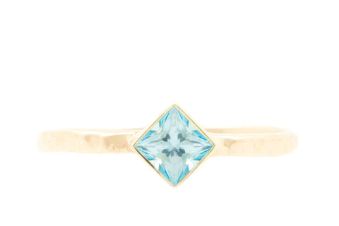 Handgemaakte en fairtrade geelgouden gehamerde ring met vierkante blauwe topaas