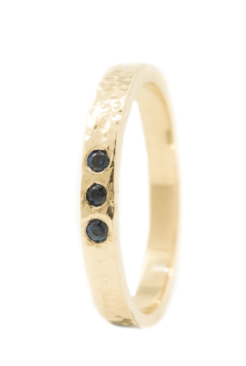 Handgemaakte en fairtrade ringen van gedutst goud met een drie donkerblauwe saffiertjes