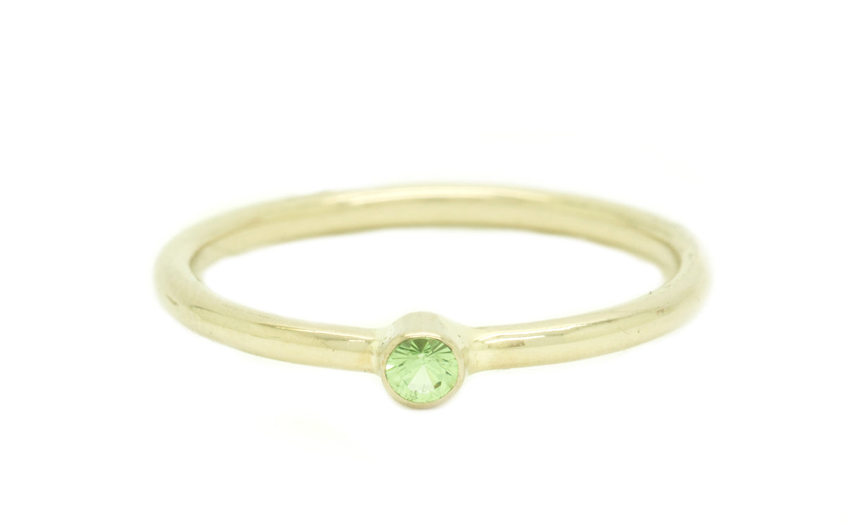 Handgemaakte en fairtrade fijne witgouden ring met groene fairtrade tsavoriet