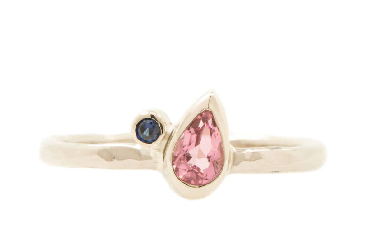 Handgemaakte en fairtrade fijne witgouden ring met roze druppelvormige toermalijn en blauwe saffier
