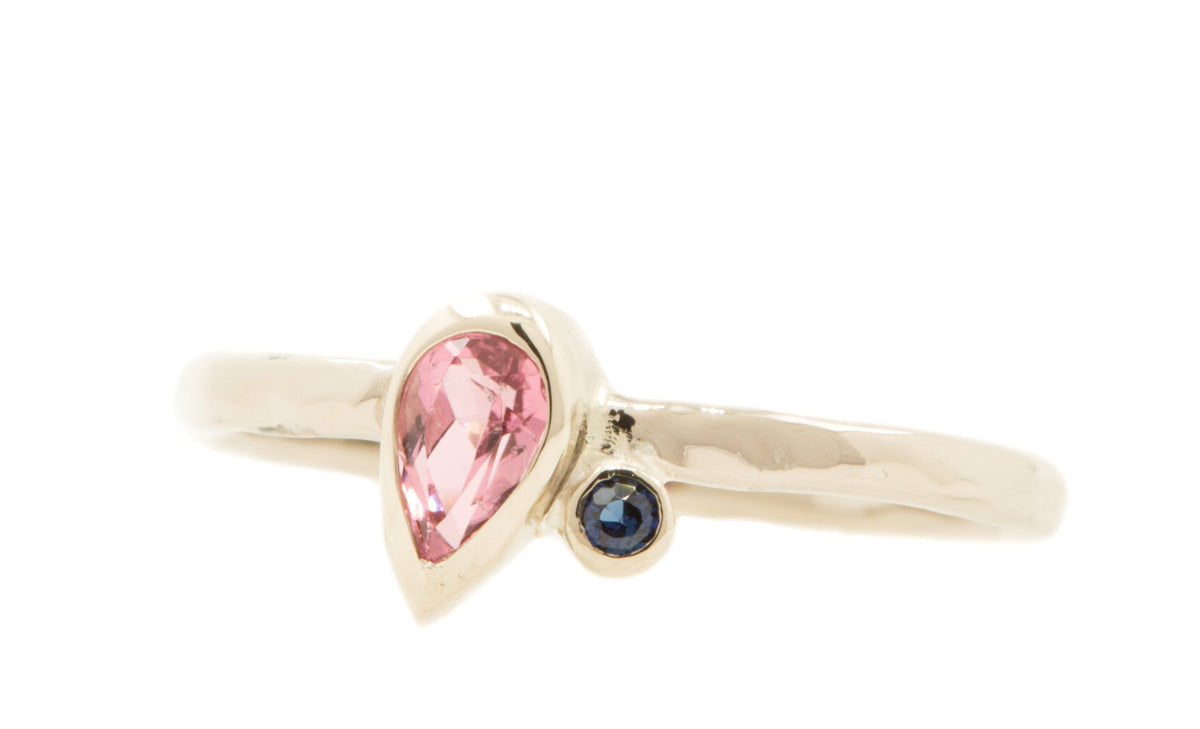 Handgemaakte en fairtrade fijne witgouden ring met roze druppelvormige toermalijn en blauwe saffier