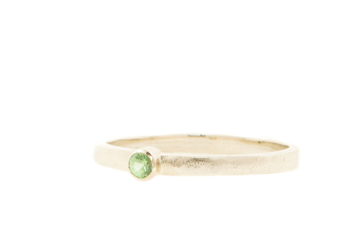 Handgemaakte en fairtrade witgouden ring met groene tsavoriet