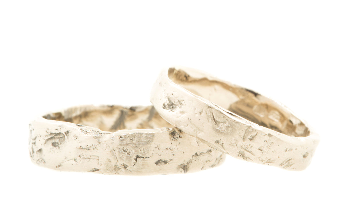 Handgemaakte brede gematteerde trouwringen van 14 kt fairtrade witgoud met het motief van een boomstam