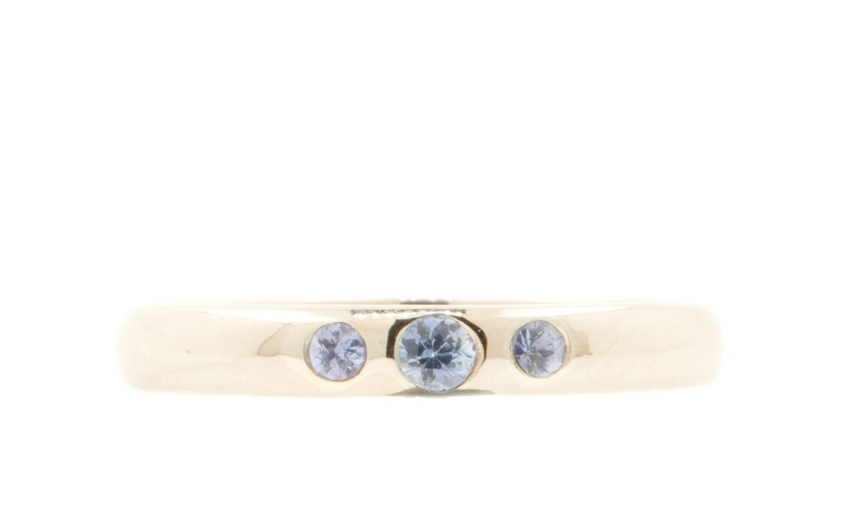 Handgemaakte en fairtrade gepolijste ring van 14 karaat witgoud met drie lichtblauwe saffieren